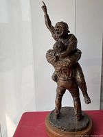 Full front view of sculpture showing two baseball players in celebratory pose on wooden base