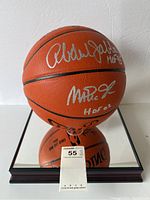Basketball with silver signatures of Kareem Abdul-Jabbar and Magic Johnson on mirrored display case