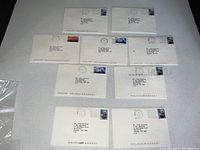 Nine white envelopes arranged on tabletop with typed addresses and postage stamps