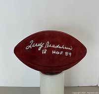 Close-up front panel view of football showing silver ink signature