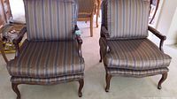 Front view of two chairs side by side showing striped upholstery and wood frames