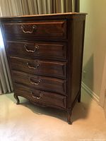 Front view of five-drawer dresser showing curved drawer fronts and finish