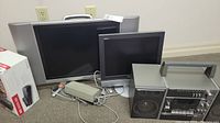 Multiple electronics including a Rogers Box CRT TV, a Sharp flat-screen TV, a Samsung smaller flat-screen TV, and Yamaha radio cassette player with speakers and remote controls on the floor.