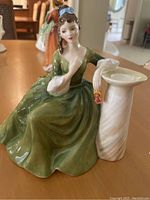 Full view of the Royal Doulton figurine seated woman in green dress with pillar detail.