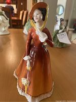 Full view of the Royal Doulton Julia figurine standing on a table showing dress and parasol detail.