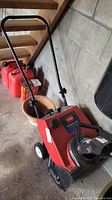 Red Toro Powerlite 3.25 HP Snowblower stored indoors, showing overall condition and handle
