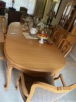 Photo of the wood dining table with one leaf inserted, showing overall finish and access from chairs.