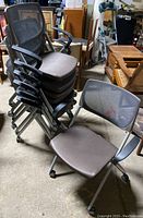 Seven Allsteel office chairs stacked together and one chair placed separately showing mesh back, padded brown seat, and armrests.