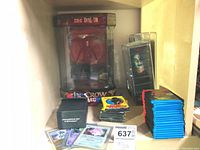 Photo showing two The Crow Eric Draven figurines in packaging, sealed Topps card packs, a collection of Pokemon cards in protective sleeves and a black pouch bag.