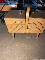 Closed view of the wooden fold-up sewing chest with handle and legs
