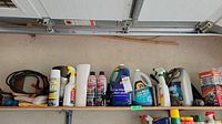 Shelf with automotive oils and car wash bottles, brushes and cleaning cloths