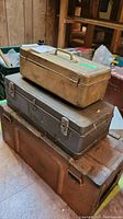 Stacked view of three metal tool boxes of different sizes and colors.