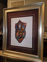 Photo of full framed painting showing colorful abstract smiling man figure with metallic silver frame and double matting.