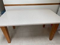 Top view showing white speckled stone surface and wood legs at corners