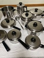 Overhead view of all Lifetime stainless steel cookware pieces laid out on white cloth