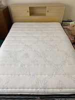 Full view of double bed frame and mattress set showing the sliding headboard and mattress surface with quilted pattern.