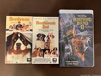 Front covers of the three VHS tapes showing titles and dog images