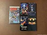Five VHS tapes displayed with front cover artwork visible including Batman, Batman Returns, Batman Forever, Batman & Robin, and Batman: Tales of the Dark Knight.