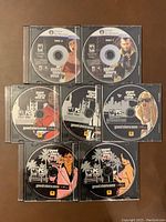 Eight Grand Theft Auto PC game discs with artwork for GTA 3, GTA 4, Vice City, and San Andreas.