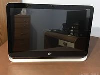 Front view of HP Pavilion 23 All-in-One desktop computer with black screen and silver base.