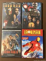 Front view of four DVD cases: Iron Man 1, Iron Man 2, Iron Man 3 movies, and Iron Man Armored Adventures Season 1 animated series, showing cover artwork and actors.