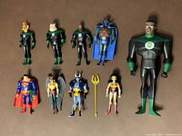 Ten Justice League action figures posed on a flat surface, showing primarily Green Lantern members John Stewart, Kilowag, Tomar-Re, along with Martian Manhunter, Superman, Hawkgirl, Blue Devil, and Wonder Woman.