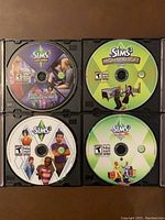 Four Sims 3 discs in CD case: Late Night Expansion Pack, High End Loft Stuff, 70's 80's 90's Stuff, and base game disc.