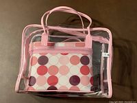 Four storage bags nested inside each other. The outer is clear with pink trim and handles, showing the patterned fabric bag inside.
