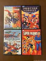 Front covers of four Justice League and Super Friends DVDs showing artwork of iconic DC superheroes in action poses.