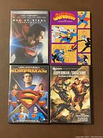 Top view of four DVD cases showing titles: Man of Steel, The Amazing Story of Superman, Superman the Animated Series, and Superman/Shazam: The Return of Black Adam.