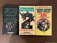 Front cover photo of three Teenage Mutant Ninja Turtles VHS tapes in their cases: The Movie (Alliance Edition), II The Secret of the Ooze, and III.