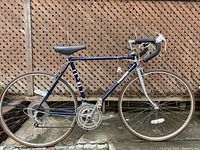 Side view of vintage blue Pacer 12-speed bicycle showing full frame, wheels, chainset, and tires.