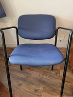 Front view of a blue fabric office chair with black metal frame.
