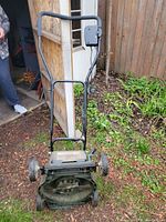 Front view of the electric lawn mower showing handle, wheels, and motor housing.