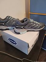 Side view of gray women's hiking shoes on box showing Dr. Scholl's brand and overall condition.
