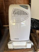 Front and angled side view of the white Amcor portable air conditioner showing front vent and control panel.