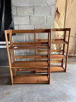 Two wooden folding bookcases positioned side-by-side, showing their overall structure and shelving.