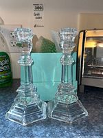 Pair of clear crystal candle holders shown on countertop with Tiffany & Co light blue box in background.