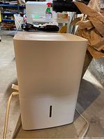Full view of the white GE dehumidifier showing the front and part of the water tank area.