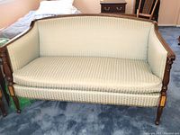Front view of the light damask upholstered Hickory Chair settee loveseat showing detailed wood work on arms and legs