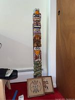 Front view of the painted wood totem with sand art pieces at base