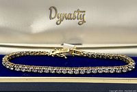 Close-up view of the 925 silver gold-toned crystal tennis bracelet inside its Dynasty box with blue velvet lining.