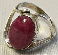 Close-up of the front and top view of the sterling silver ring featuring an oval semi-precious pink stone in a bezel setting.