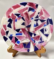 Front view of the circular fused glass bowl showing the colorful geometric mosaic pattern.