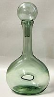 Front view of the mid-century modern smoked glass decanter bottle with stopper on top.