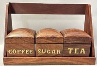 Front view of wooden shelf with three canisters labeled Coffee, Sugar, Tea