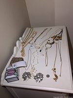 Overview of all items arranged on table including jewelry, trinket box, and candle holders.