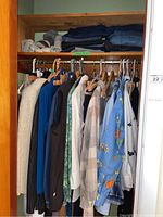 Photo of hanging women's sweaters, blouses, jackets, and vests with multiple colors and patterns