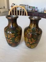 Pair of antique Chinese cloisonné vases showing the front floral design and metal rims.