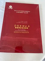 Red presentation box with gold Chinese characters and branding from Sichuan China Tourist Commodities, referencing a 2003 textile exhibition award.